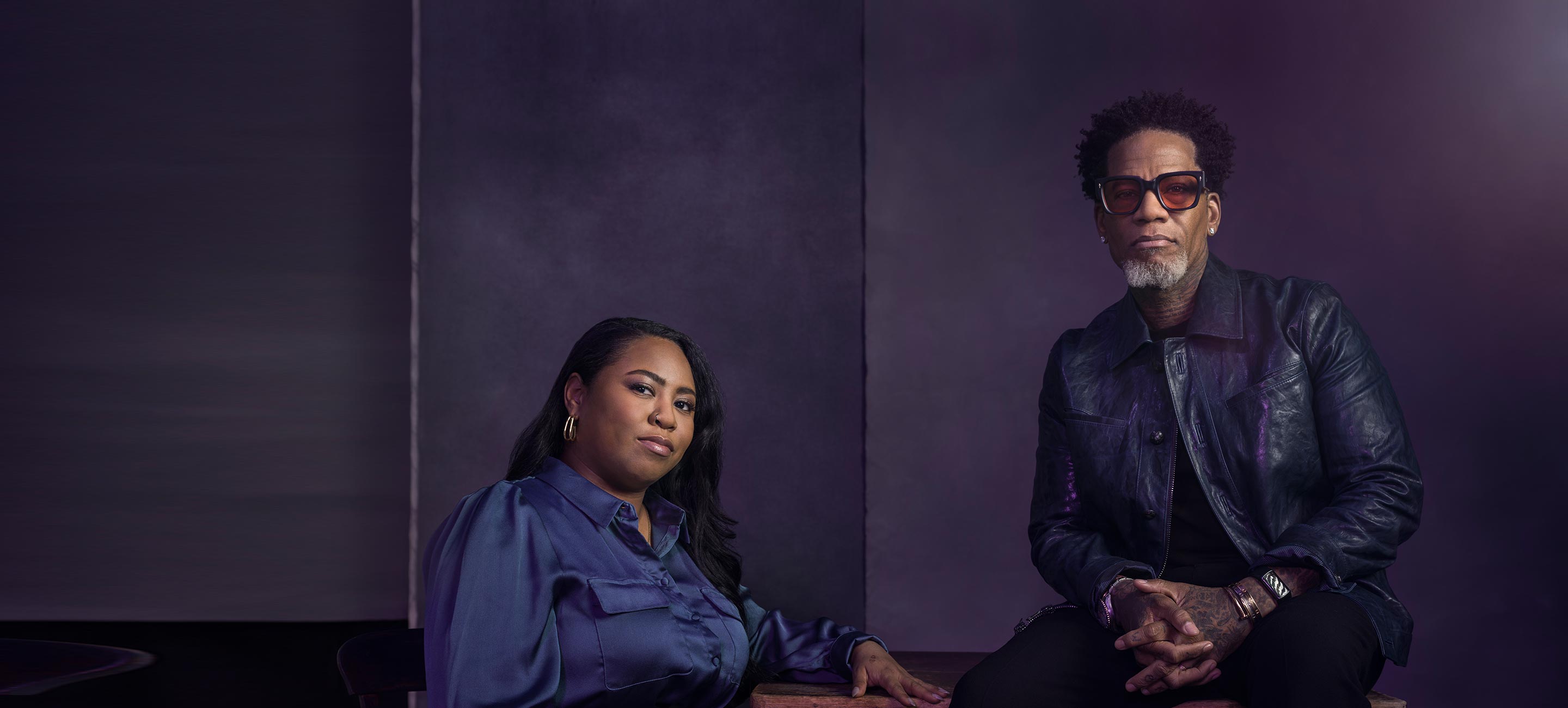 A black man & black woman seating on a chair image